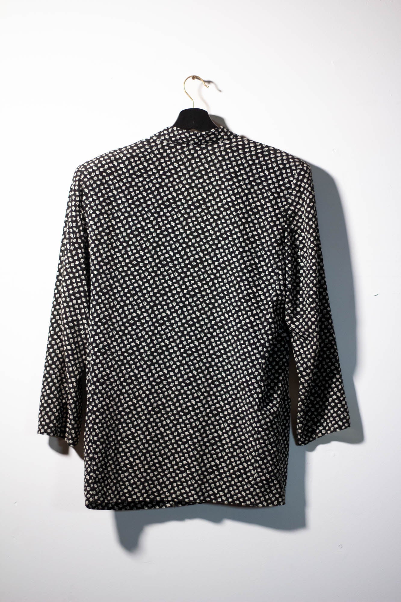 Black and white patterned shirt on a hanger against a white background