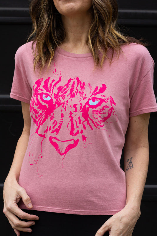 Woman wearing a pink t-shirt with a pink tiger graphic design.