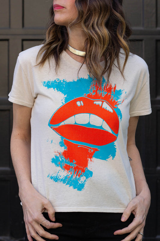 Woman wearing a t-shirt with a graphic design of red lips and blue paint splashes.