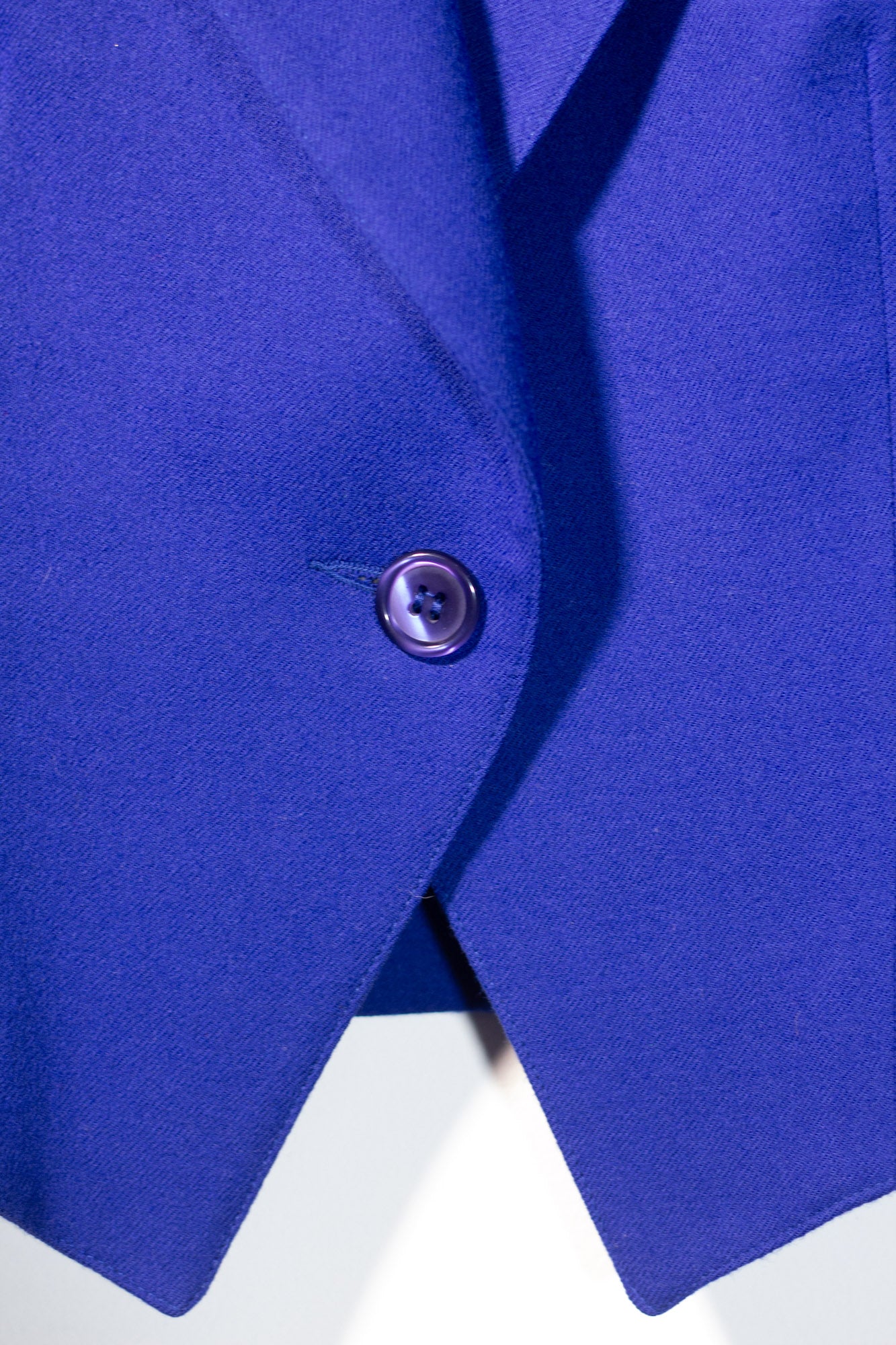 Close-up of a blue garment with a button on a white background