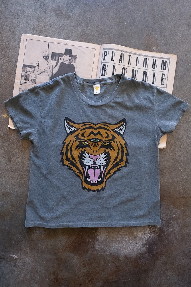 Vintage black t-shirt with a tiger graphic on a textured surface