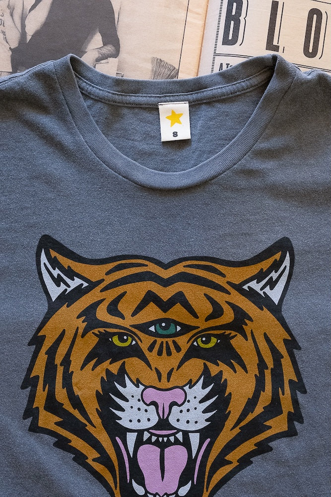 Gray t-shirt with a tiger graphic design on a textured surface