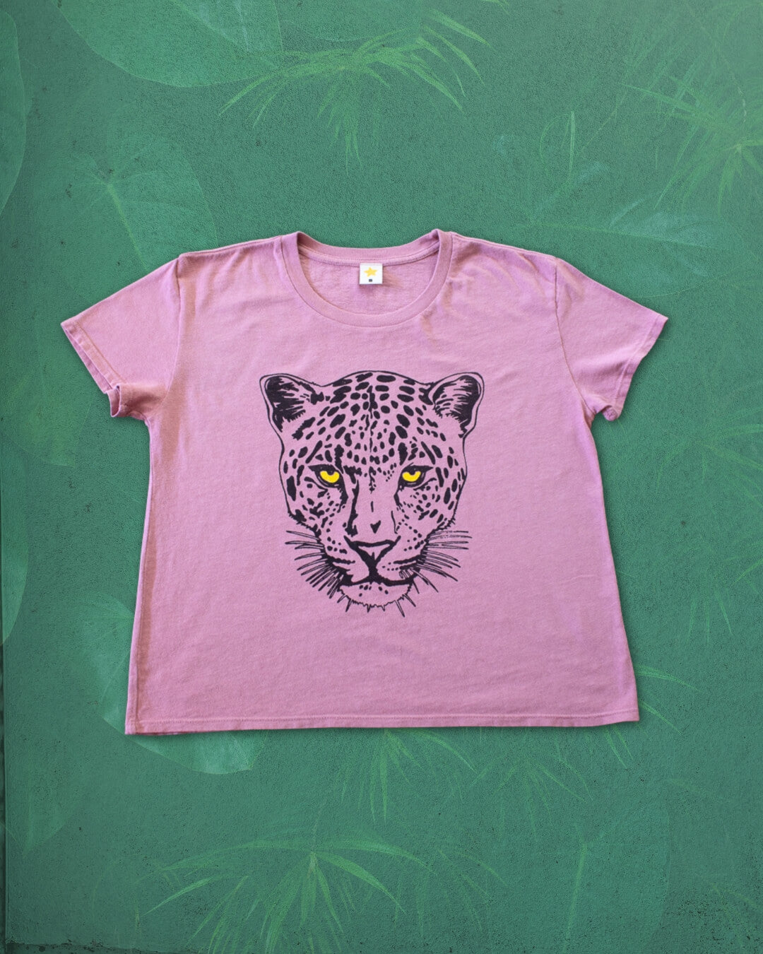 Pink t-shirt with a leopard graphic on a green textured background