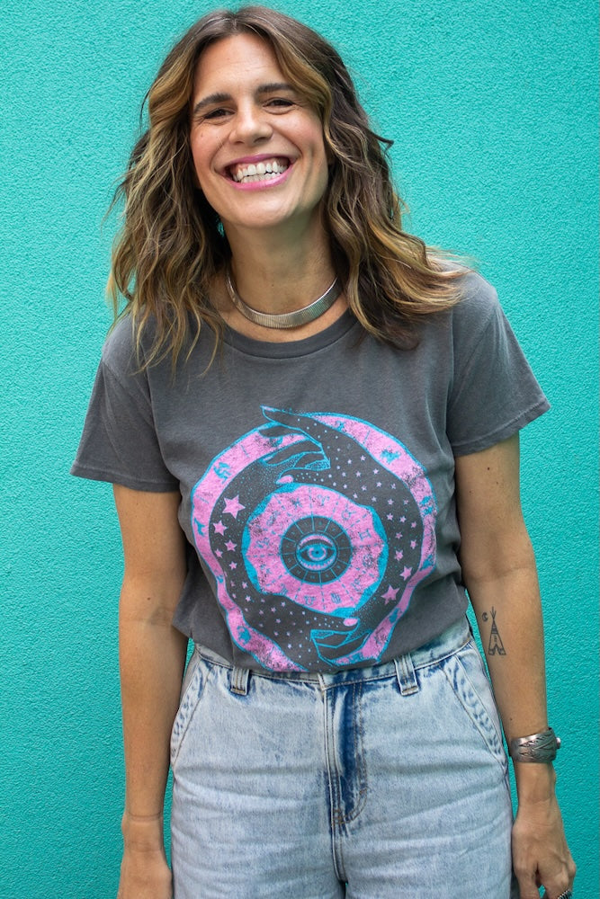 Angela wearing the Zodiac cool women’s graphic t shirt in vintage black with neon pink and blue zodiac design, front view.