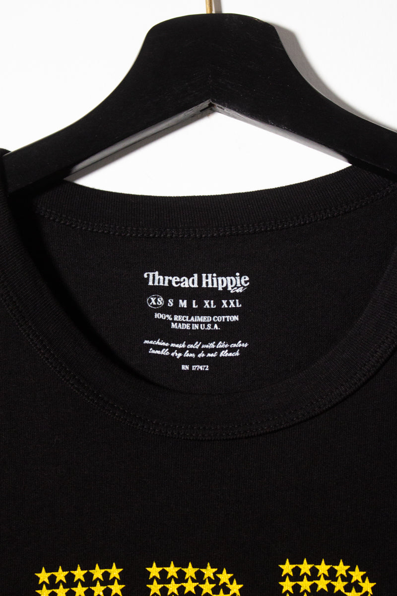 the "she's an icon" graphic tee on black