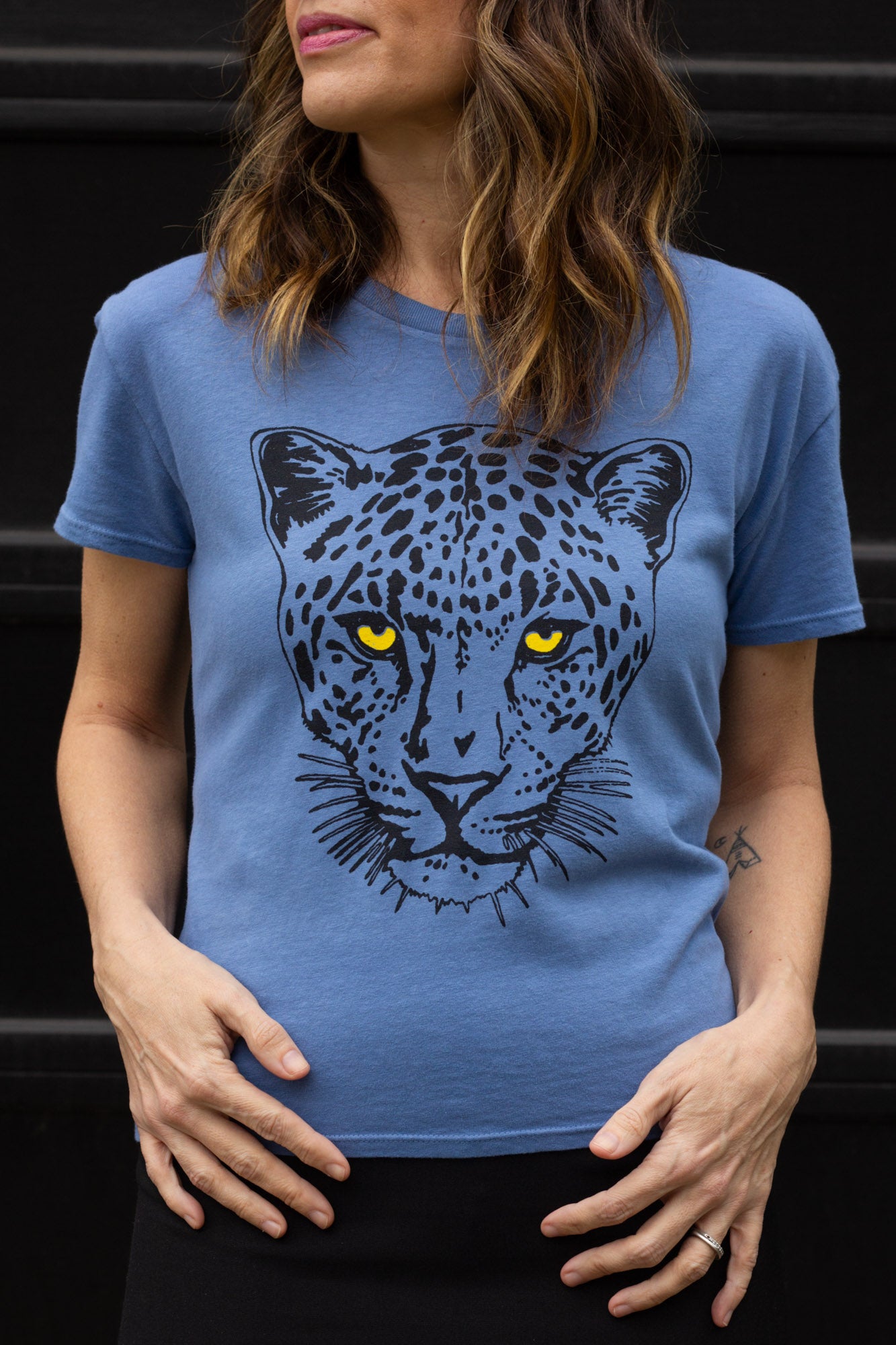 Woman wearing a blue t-shirt with a leopard graphic design.