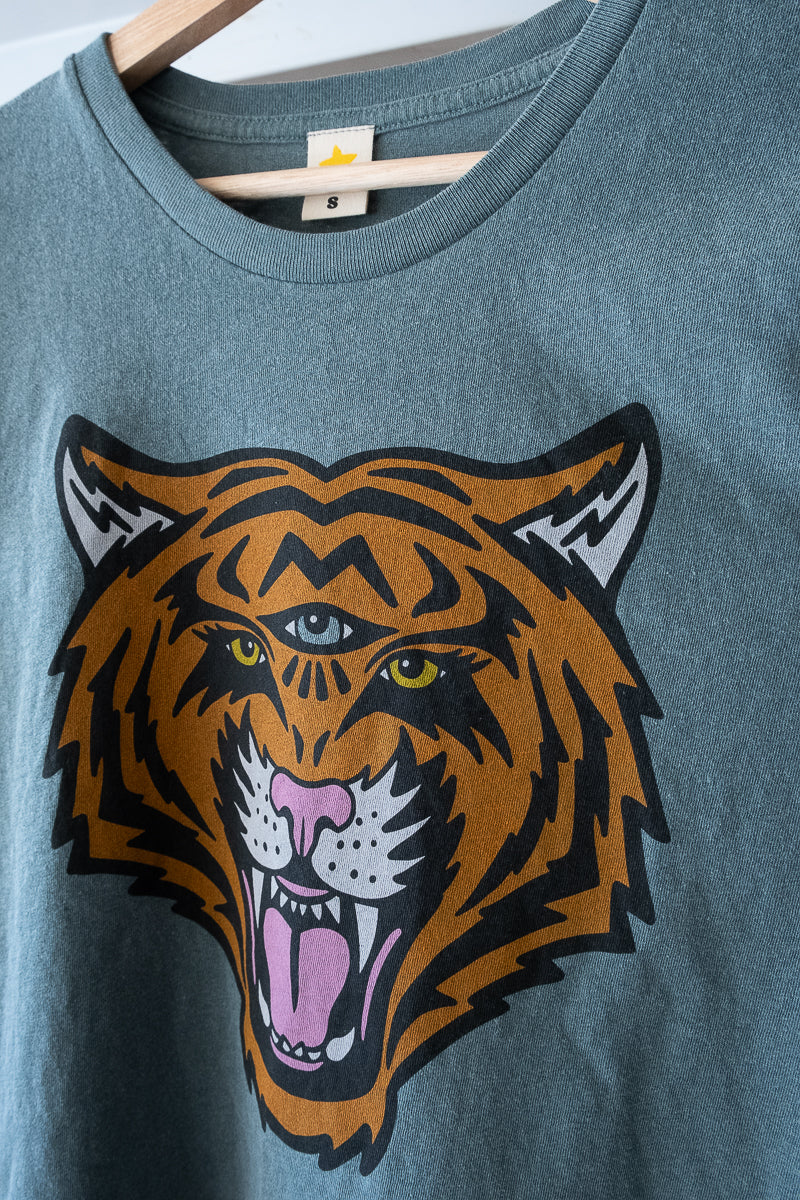 Women's Cosmic Tiger green boxy graphic tee close up hanging.