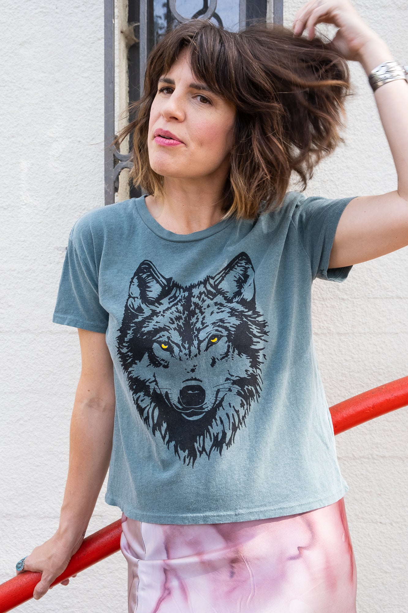 Women's Wolf green boxy graphic tee styled on model - front view.