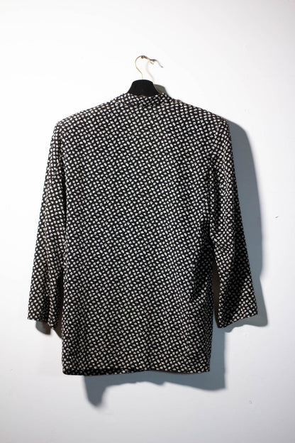 Black and white patterned shirt on a hanger against a white background