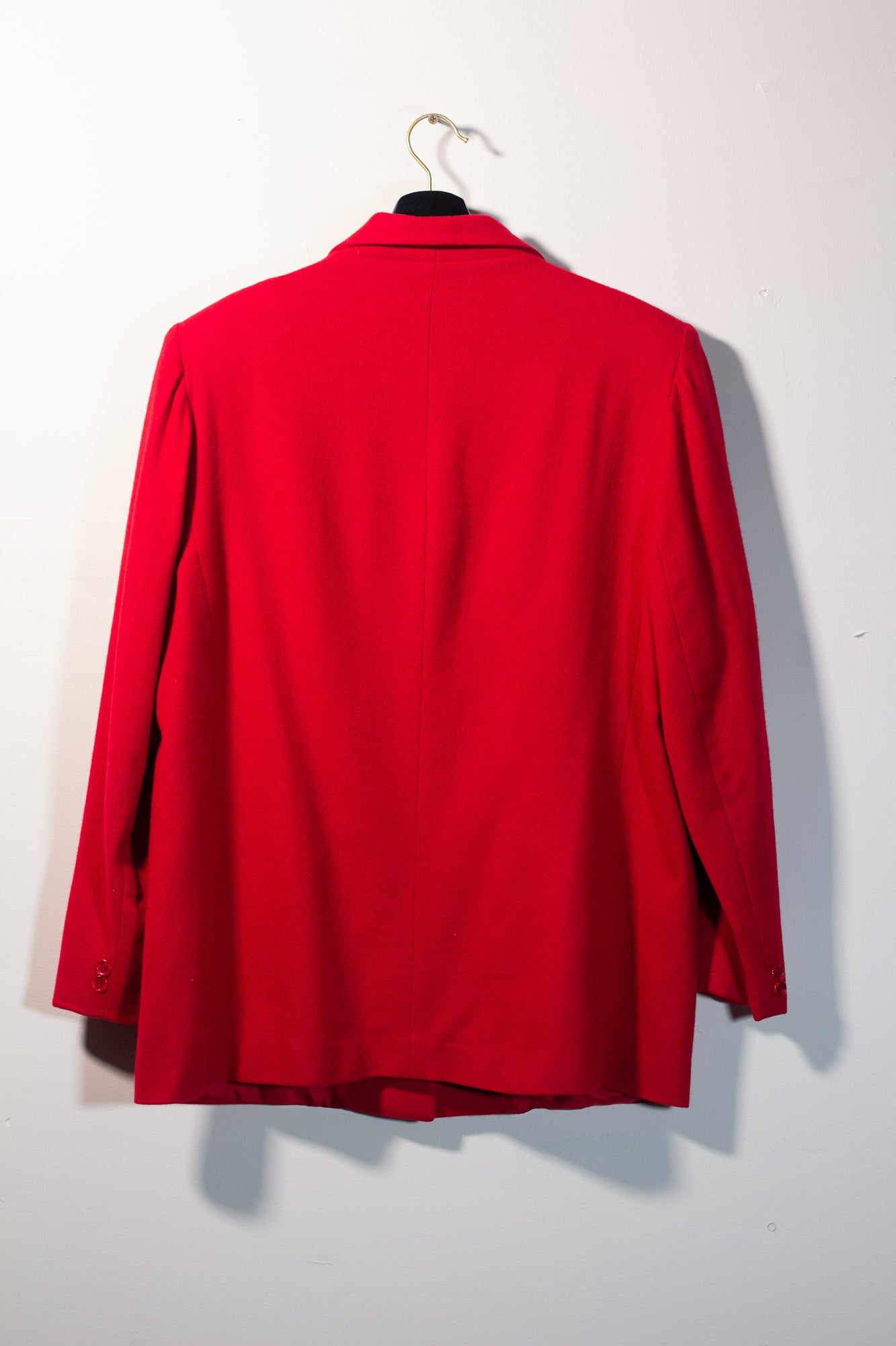 Red jacket on a hanger against a white background
