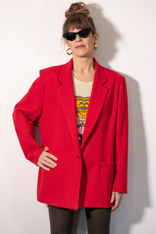 Person wearing a red blazer over a graphic t-shirt on a white background