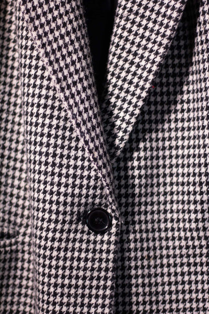 Close-up of a houndstooth patterned coat with a button.