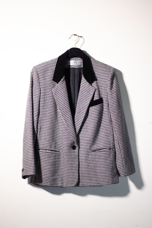 Houndstooth pattern blazer on a hanger against a white background