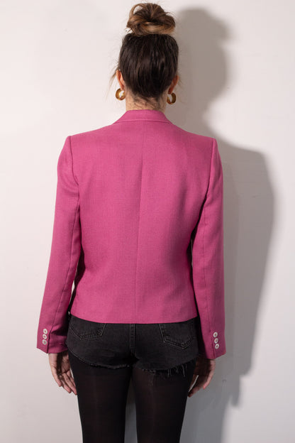 Person wearing a pink blazer from behind on a white background