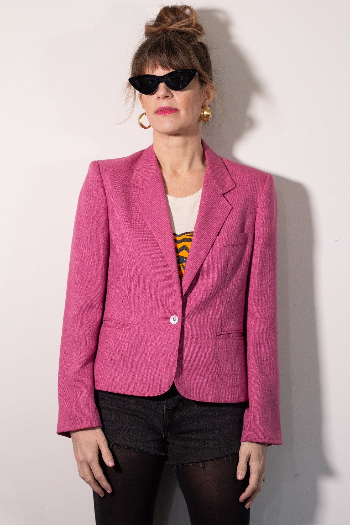 Person wearing a pink blazer against a white background
