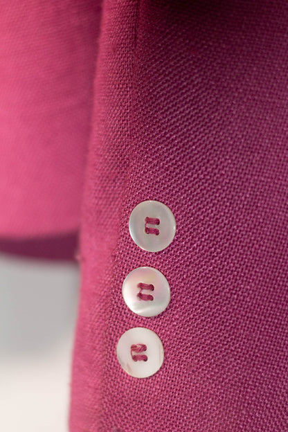 Close-up of a pink fabric with three buttons on a blurred background