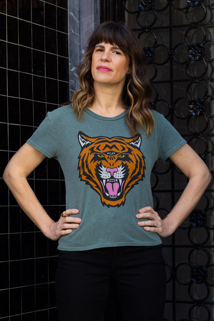 Woman wearing green cosmic tiger graphic tee downtown.