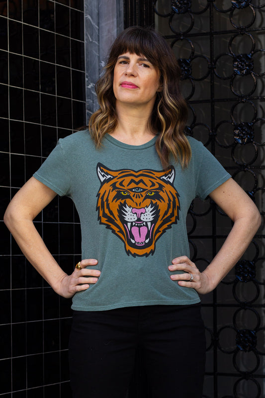 Woman wearing green cosmic tiger graphic tee downtown.