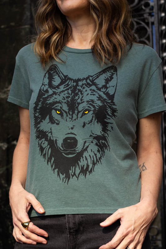 Woman wearing a green t-shirt with a wolf graphic design.