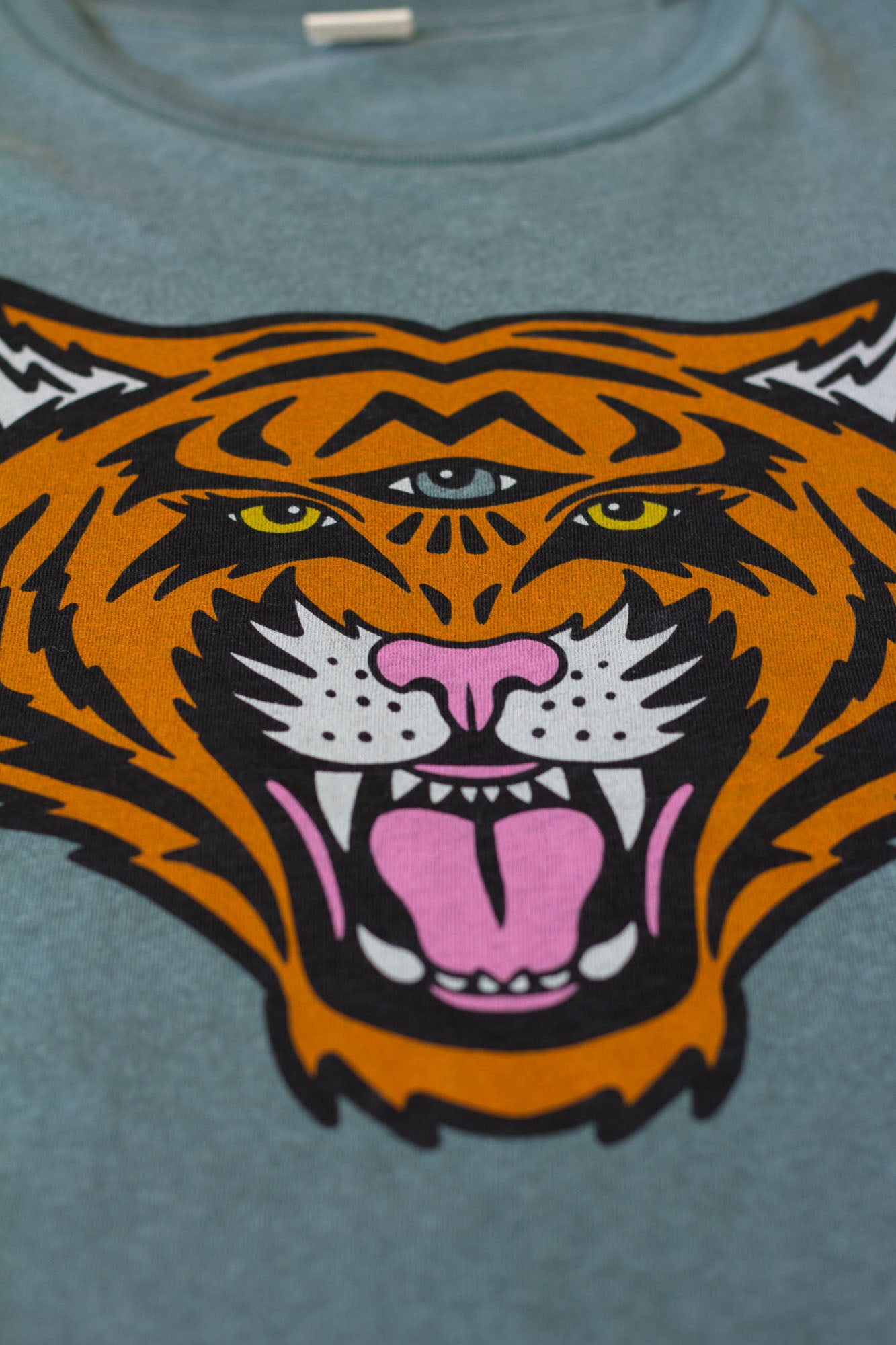 Close-up of a women's tiger graphic on a green t-shirt.