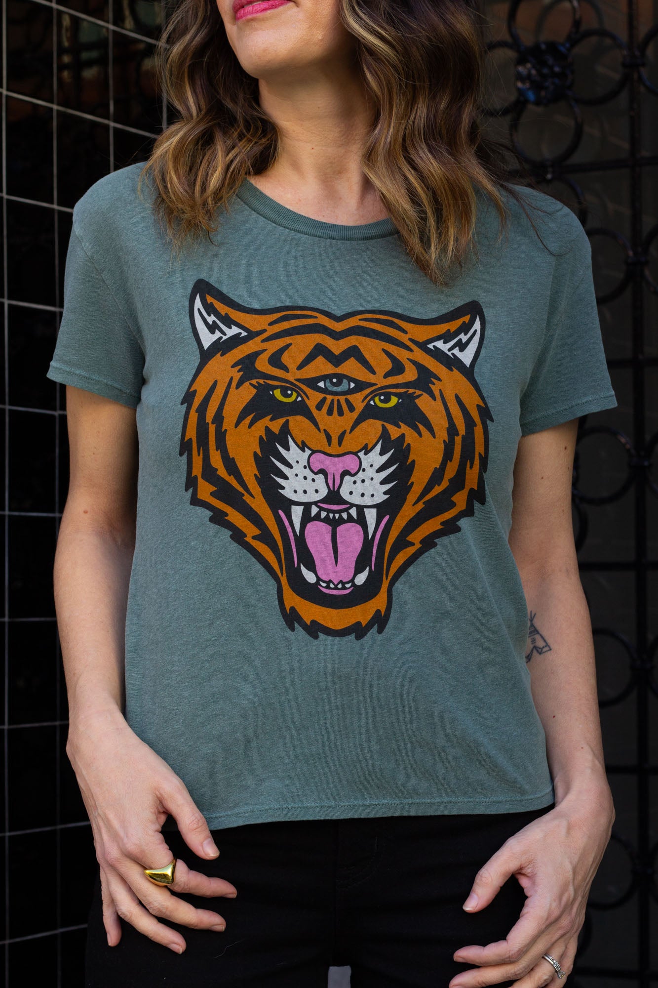 Woman wearing a green t-shirt with a tiger graphic design.