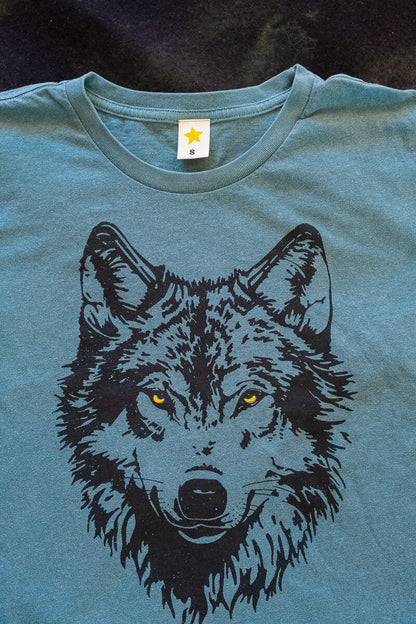 Green t-shirt with a black wolf graphic on a dark background