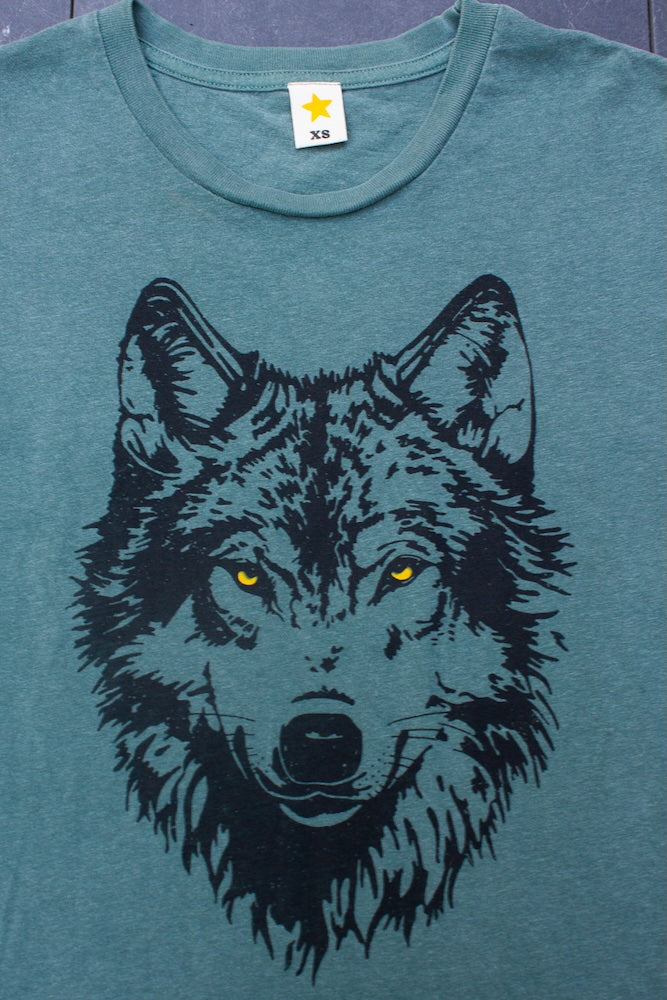 Green t-shirt with a wolf graphic on a plain background.