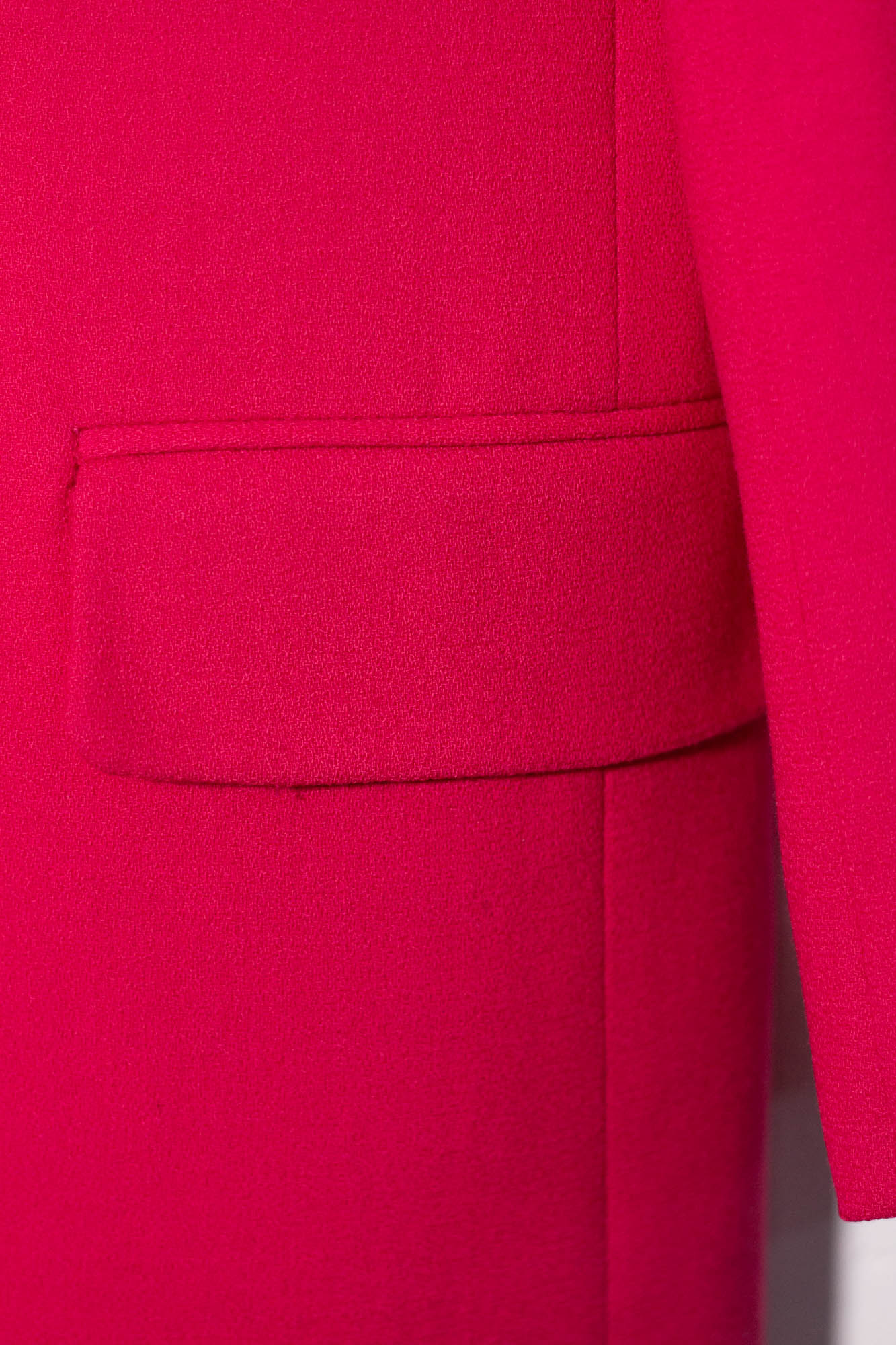 Close-up of a bright pink garment with a pocket detail.