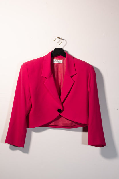 Pink blazer on a hanger against a white background