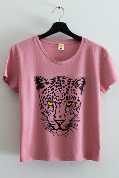 Pink t-shirt with a leopard graphic on a hanger against a white background