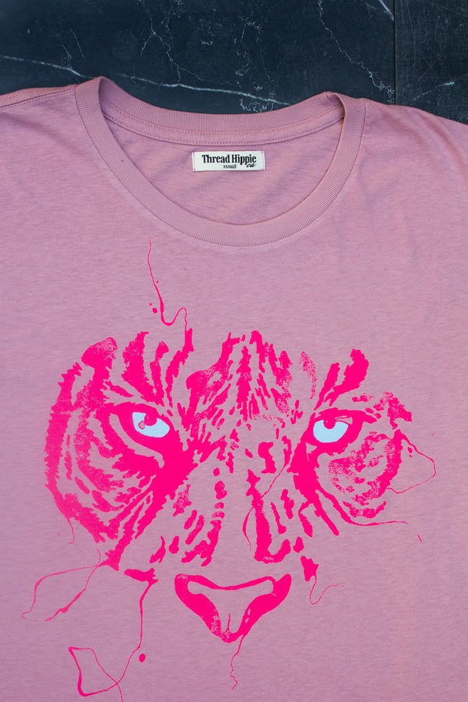 Detail photo of tiger eye graphic on pink women's t-shirt.
