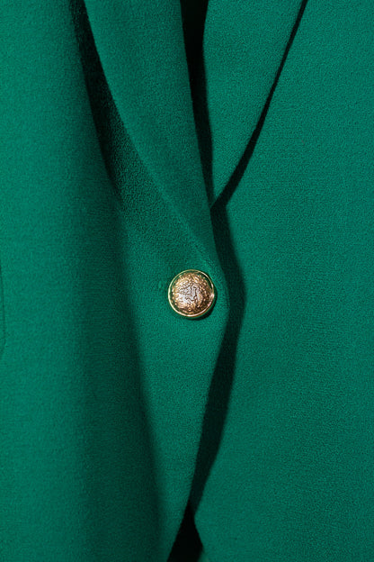 Close-up of a green garment with a gold button