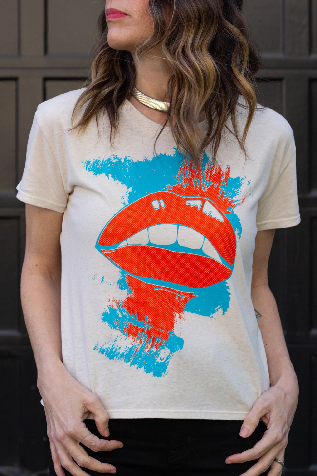 Woman wearing a t-shirt with a graphic design of red lips and blue paint splashes.