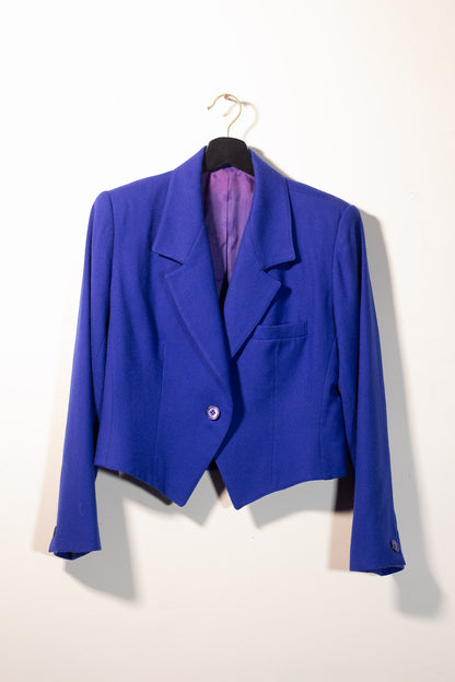 Blue blazer on a hanger against a white background
