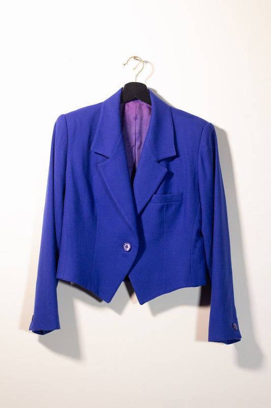 Blue blazer on a hanger against a white background