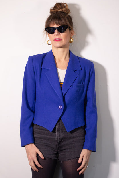 Person wearing a bright blue blazer against a white background