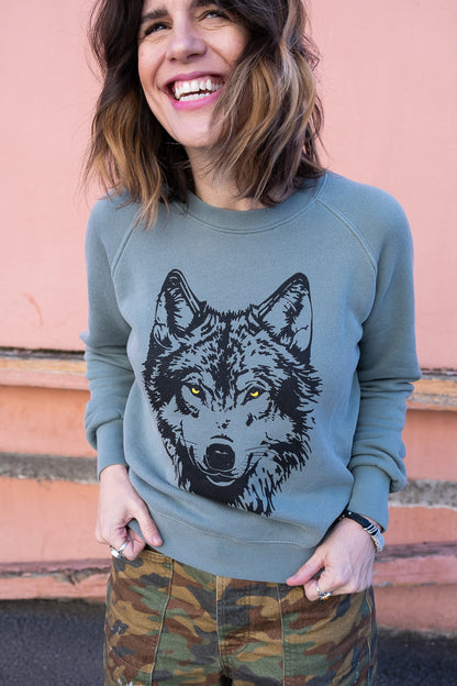 Thread Hippie women's wolf sweatshirt on green.