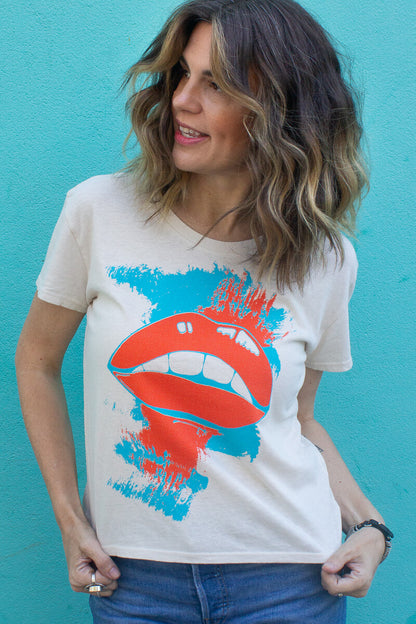 Woman wearing a white t-shirt with a colorful graphic design against a blue background