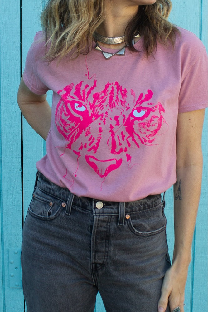 Close up photo of Angela wearing pink tiger eyes graphic tee tucked into black jeans.