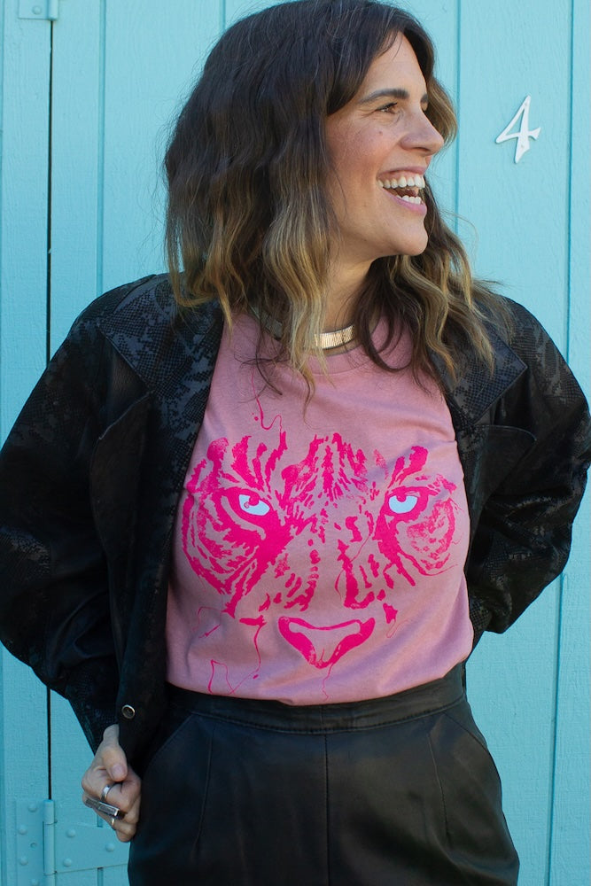 Angela wearing pink tigress t-shirt with black skirt and vintage black leather blazer.