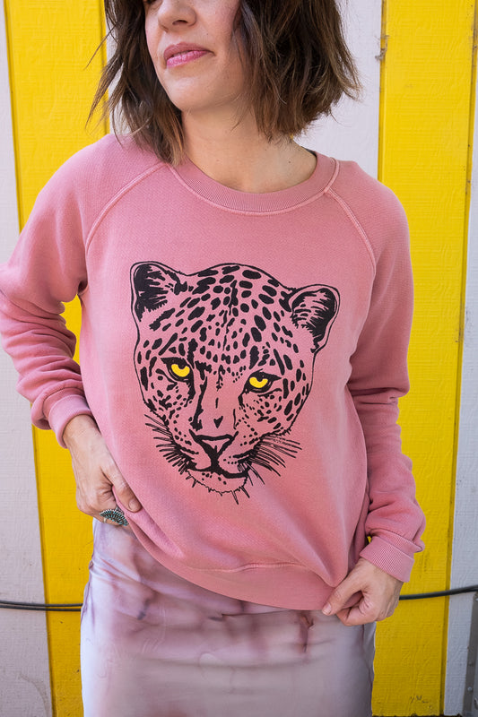 Women's Snow Leopard pink sweatshirt styled on model - front view.
