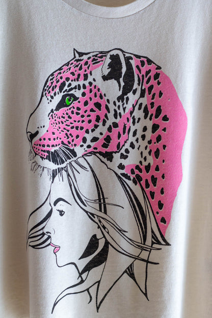 Detail photo of a white women's graphic tee with a pink leopard.