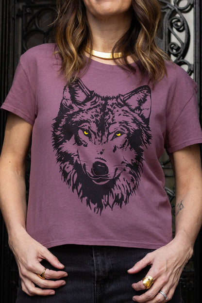Woman wearing a purple t-shirt with a wolf graphic design.