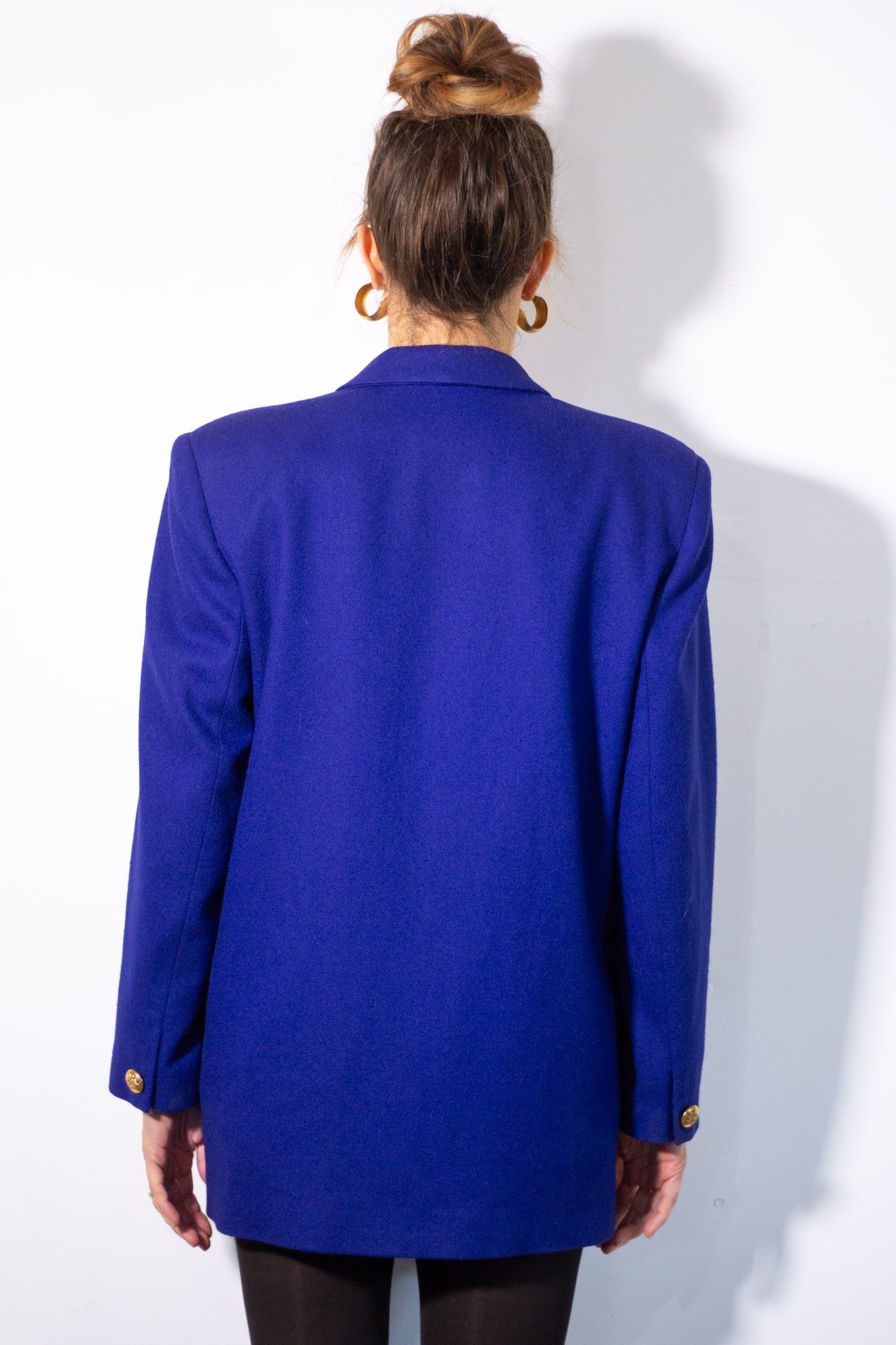 Person wearing a blue blazer from behind on a white background