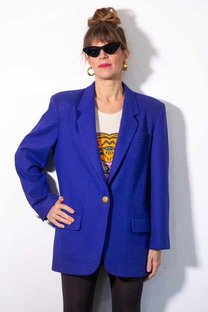 Person wearing a bright blue blazer over a graphic t-shirt on a white background