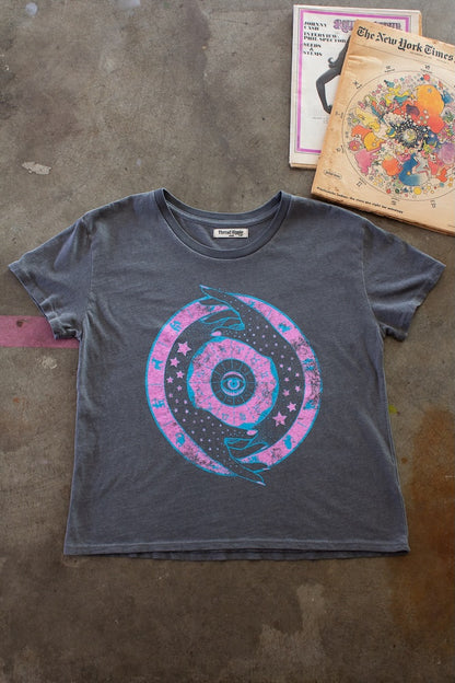 Zodiac women’s graphic tee in vintage black, flat lay with bright pink and blue ink design.